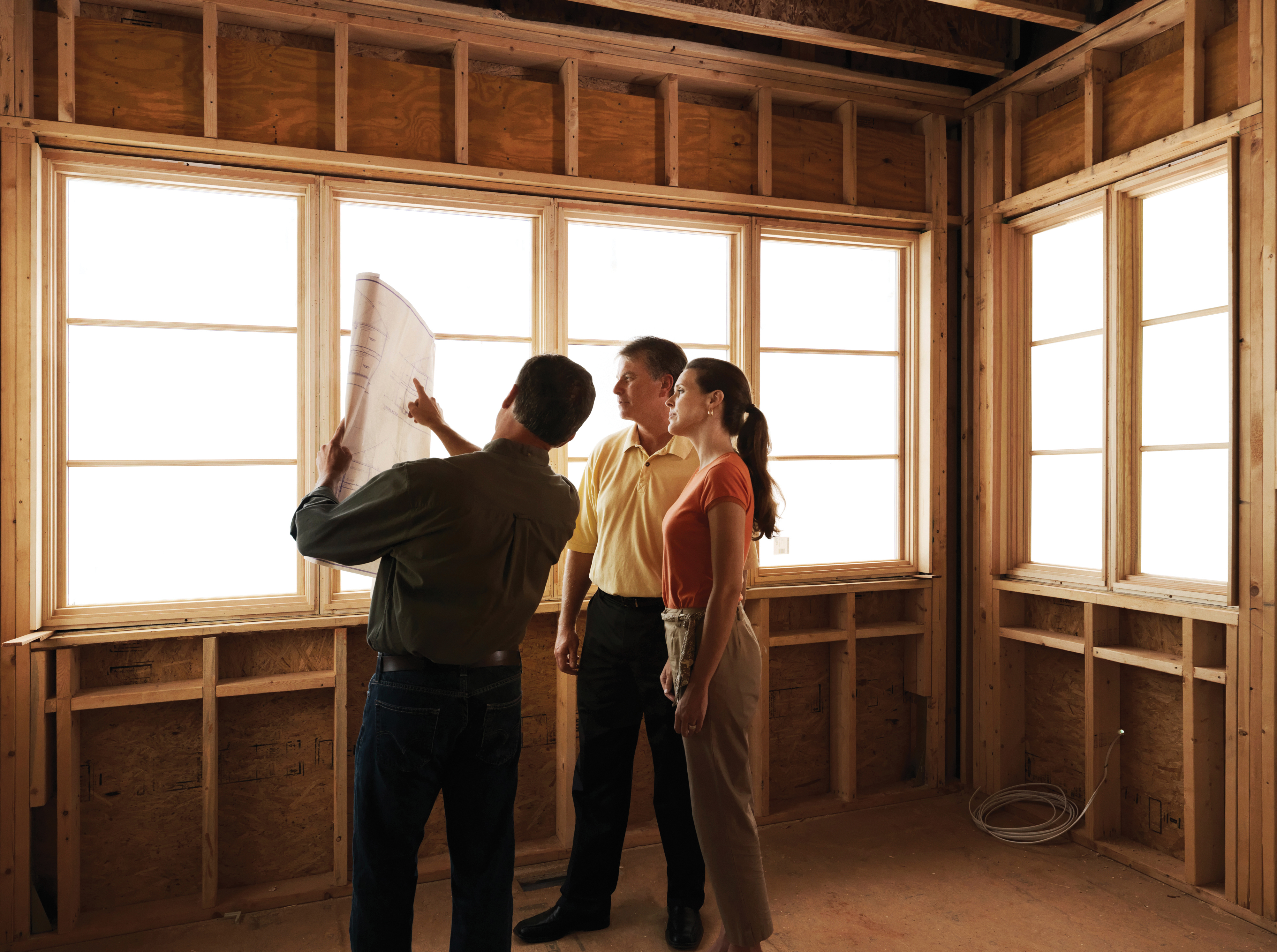 Builder reviewing new-construction windows with homeowners